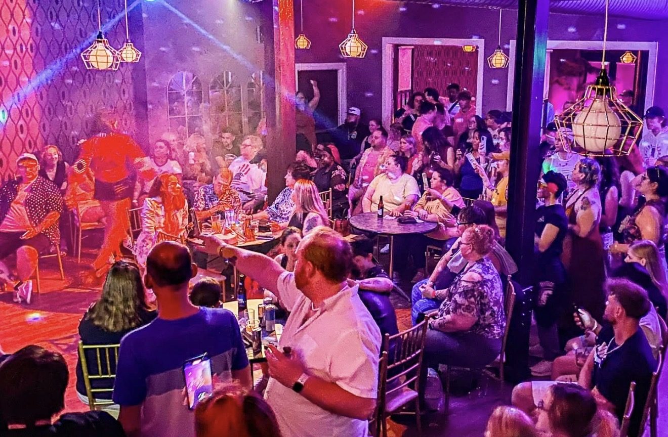 Drag show with a packed indoor crowd